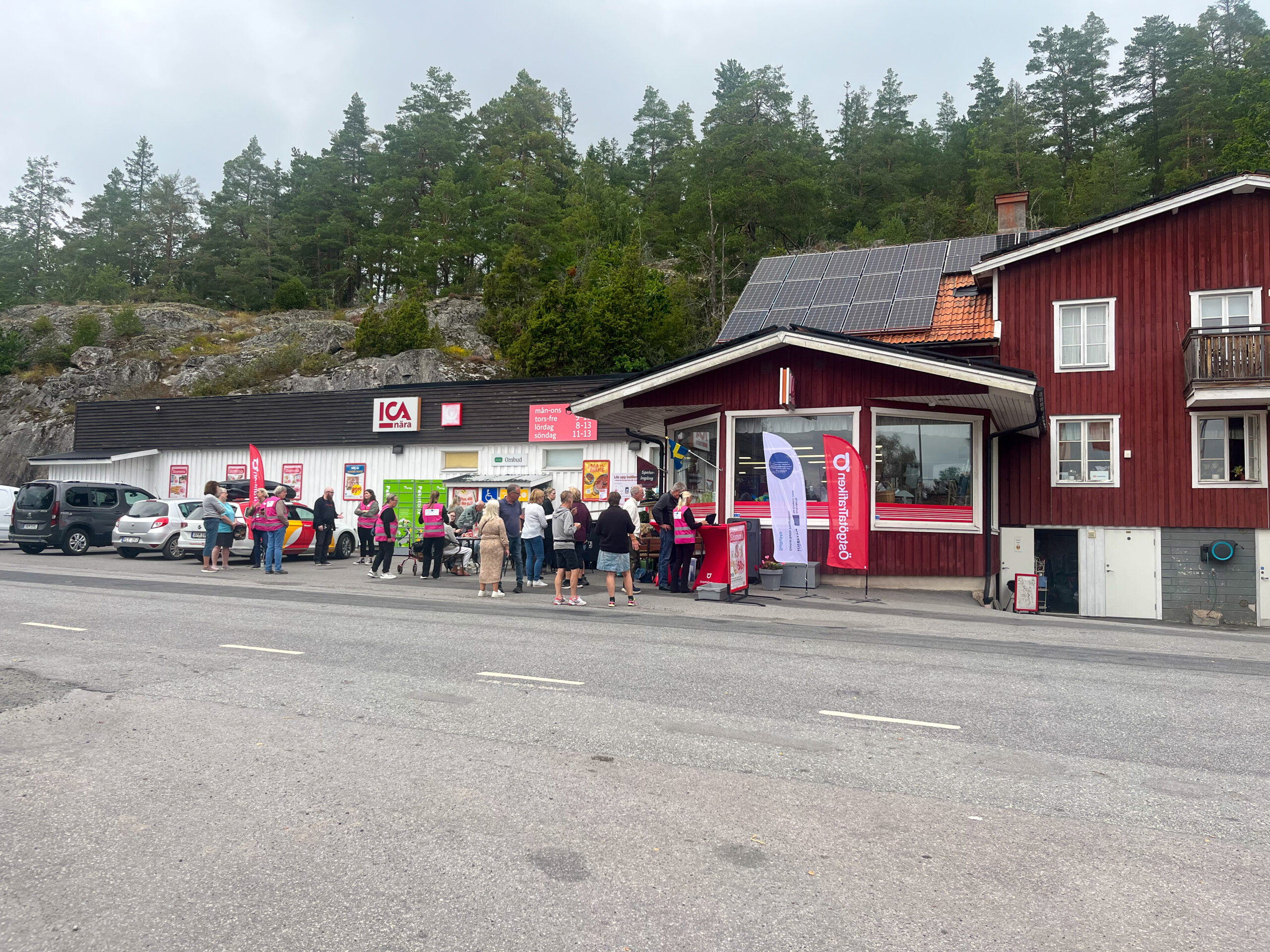 Crowd outside Sjöberga general store in Hannäs, where staff in pink vests help residents register in the carpooling app.