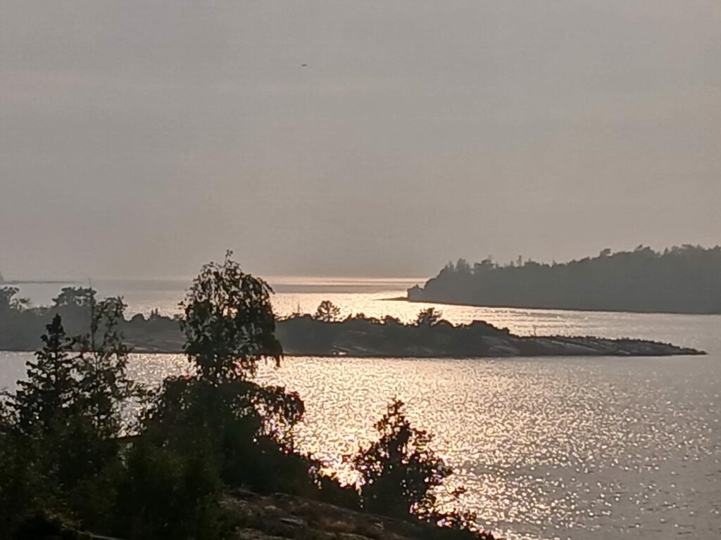 Evening sun shining over three archipelago islands and the sea in between