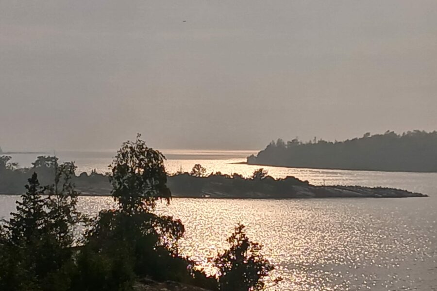 Evening sun shining over three archipelago islands and the sea in between