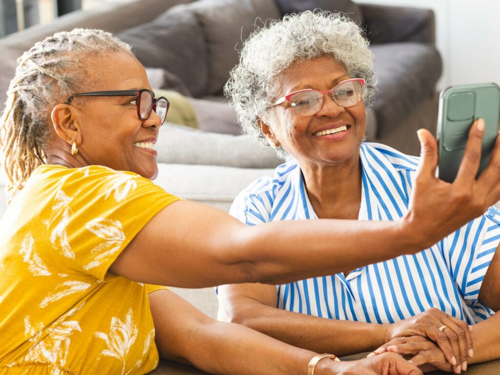 Two women cheerfully looking at a mobile phone screen