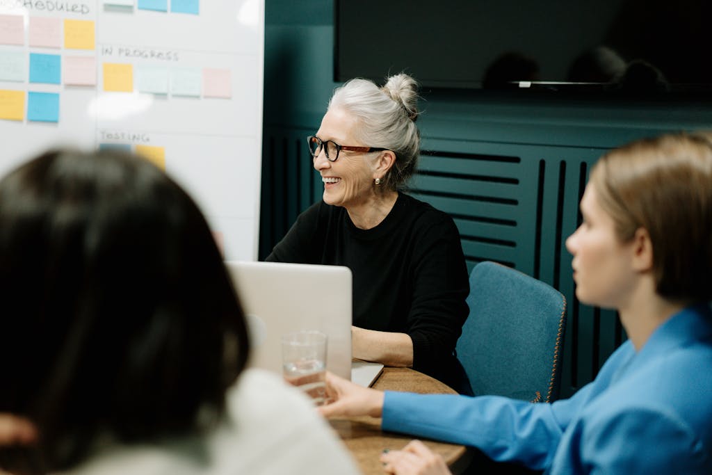 Smiling senior businesswoman leading a diverse team meeting in an office.