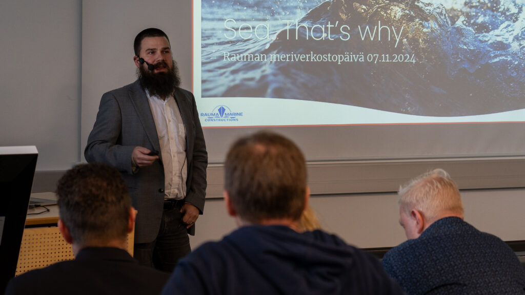 A seminar spekaer in front of a big screen