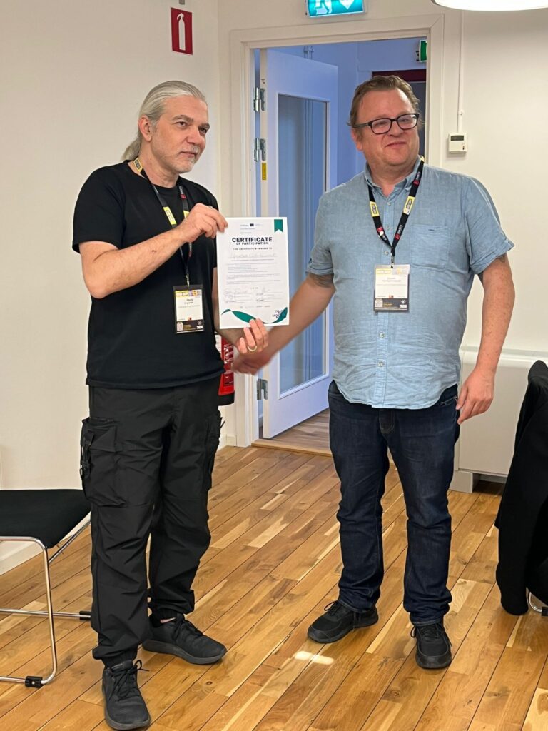 A CDG-Booster participant receiving a certificate from a lecturer. 