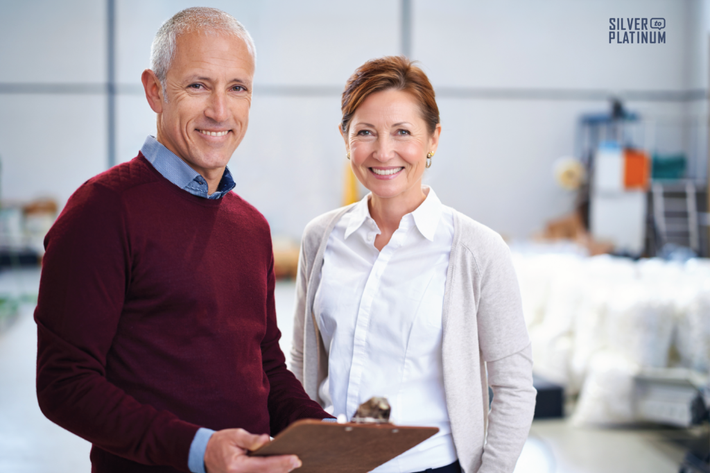 Two employees from different generations standing together in a warehouse