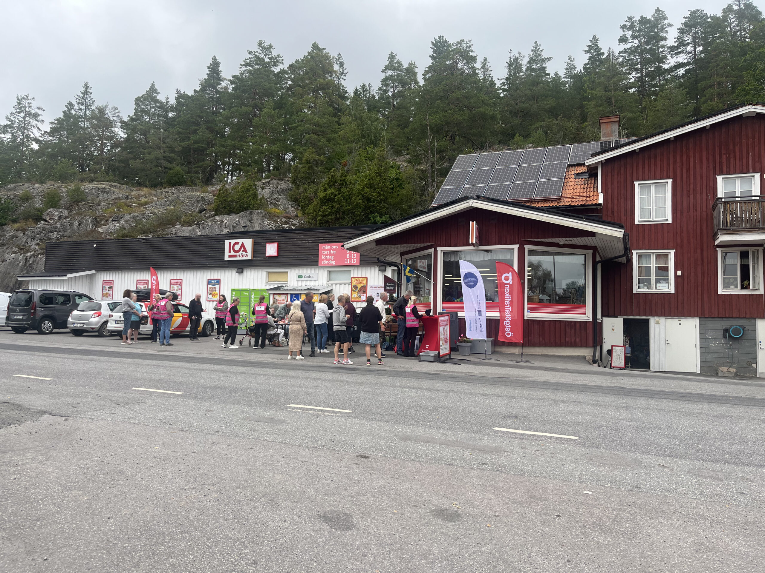 Crowd outside Sjöberga general store in Hannäs, where staff in pink vests help residents register in the carpooling app.